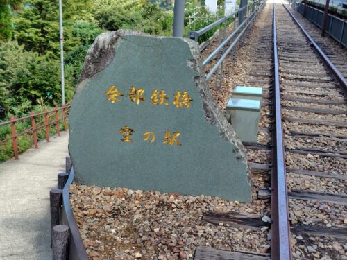 空の駅の石碑と線路の写真。